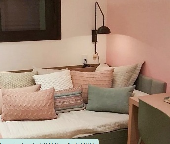 Dormitório planejado com cabeceira estofada, marcenaria em tom claro e iluminação de leitura